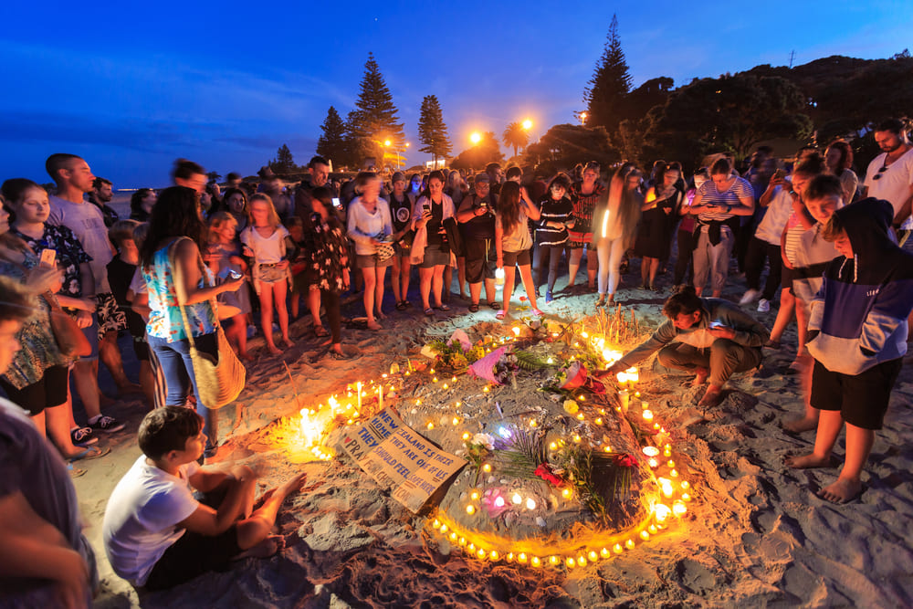 A candlelight vigil at Mount Maunganui beach, New Zealand, for the victims of the March 15 Christchurch mosque shootings. People place candles in the sand in a heart shape. Photographed March 16 2019 — Photo by MLWilliams